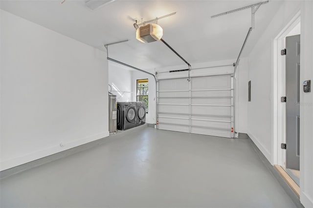 garage featuring electric water heater, a garage door opener, and independent washer and dryer