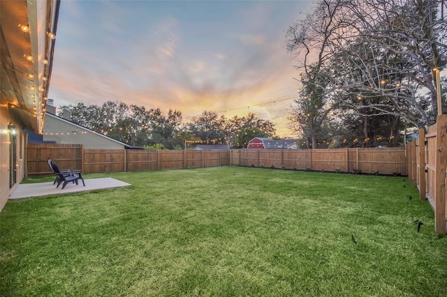 yard at dusk featuring a patio area