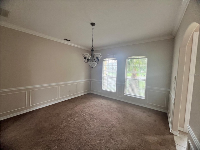 unfurnished dining area with carpet floors, a chandelier, and ornamental molding