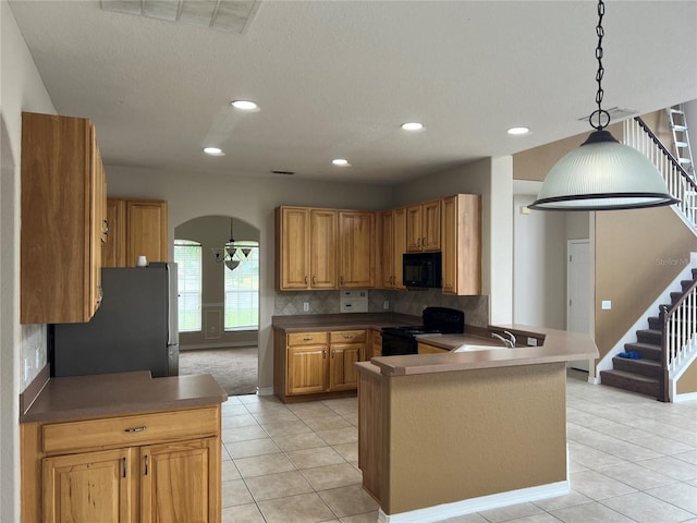 kitchen with black appliances, decorative light fixtures, tasteful backsplash, kitchen peninsula, and light tile patterned floors