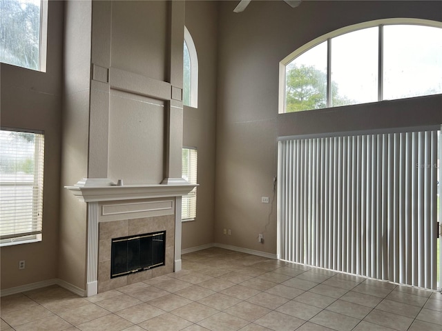 unfurnished living room with light tile patterned floors, a fireplace, and a wealth of natural light