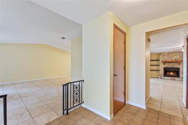 corridor featuring light tile patterned flooring and lofted ceiling