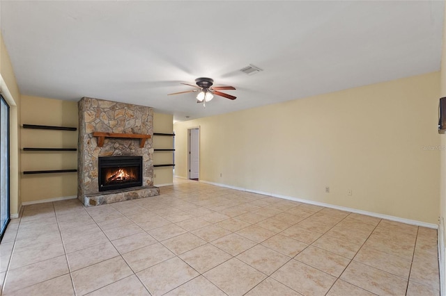 unfurnished living room with ceiling fan, light tile patterned flooring, and a fireplace