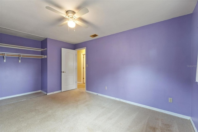 unfurnished bedroom with ceiling fan, a closet, and light carpet