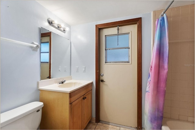 full bathroom featuring toilet, tile patterned floors, vanity, and shower / bath combo with shower curtain