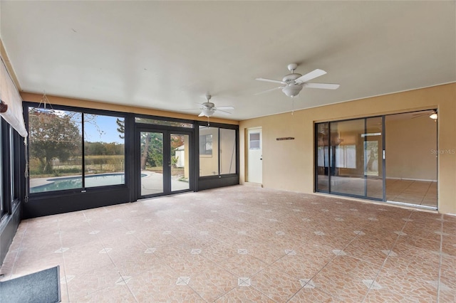 unfurnished sunroom with ceiling fan