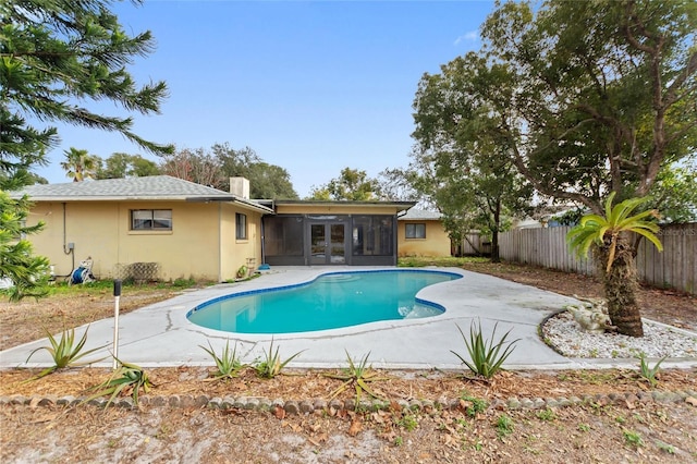 view of swimming pool featuring a patio and a sunroom