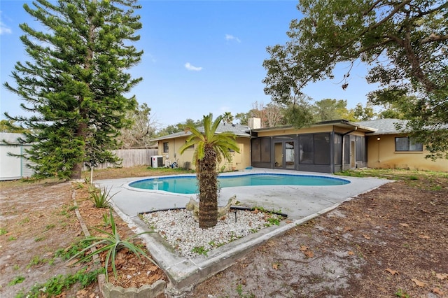 view of pool with central AC unit, a sunroom, and a patio