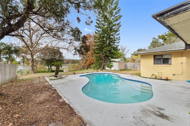 view of pool featuring a storage shed and a patio