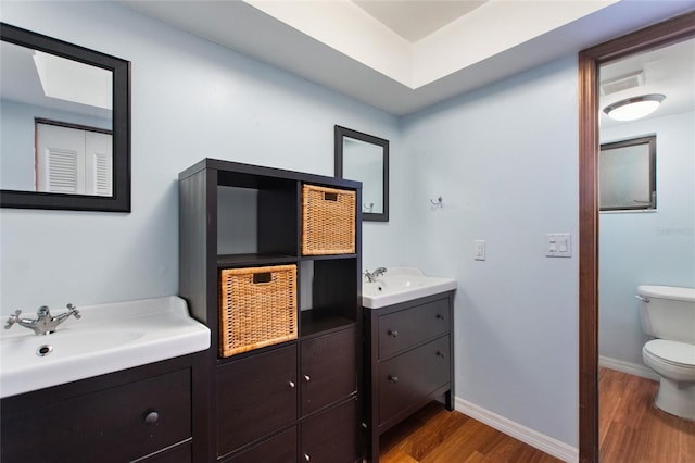 bathroom featuring toilet, vanity, and hardwood / wood-style floors