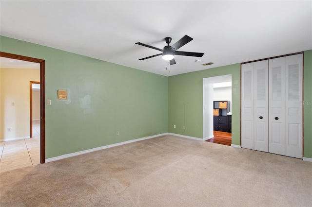 unfurnished bedroom with ceiling fan, a closet, and light colored carpet