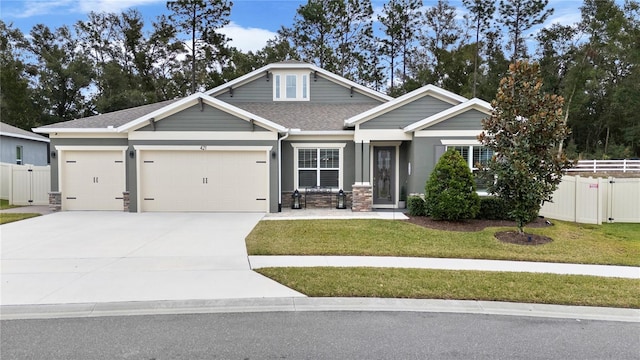 craftsman house with a front lawn and a garage