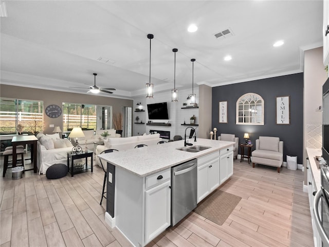 kitchen featuring white cabinets, an island with sink, sink, ceiling fan, and stainless steel dishwasher