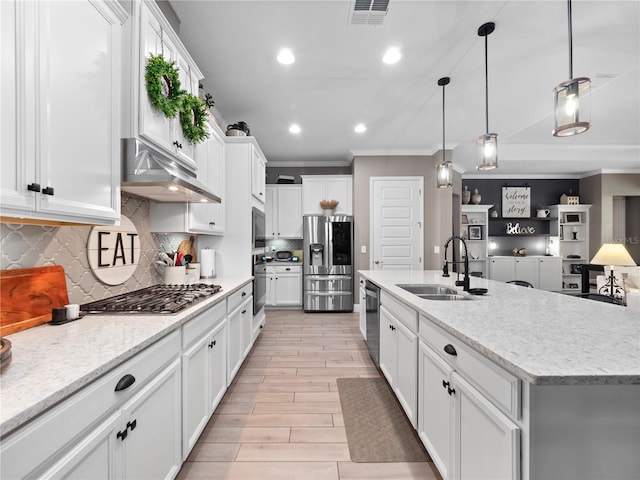 kitchen featuring appliances with stainless steel finishes, white cabinets, a large island, and sink