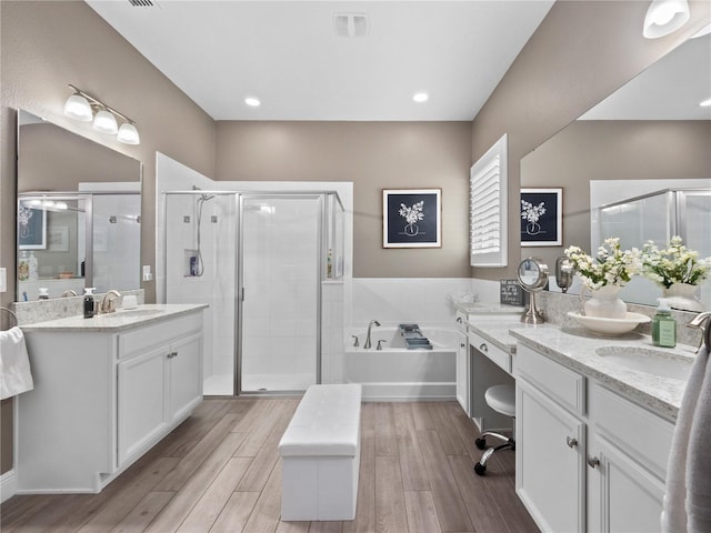 bathroom with separate shower and tub, vanity, and wood-type flooring