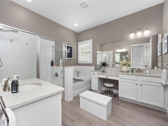 bathroom featuring vanity and independent shower and bath