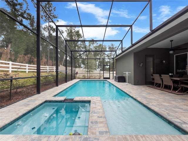 view of swimming pool featuring glass enclosure and a patio