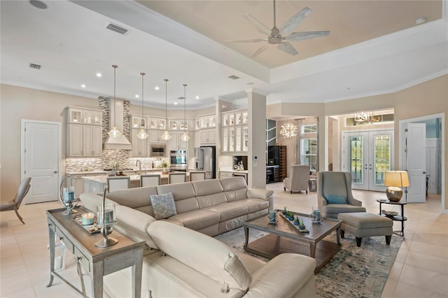 living room featuring french doors, light tile patterned flooring, ceiling fan with notable chandelier, and ornamental molding