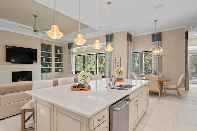 kitchen featuring decorative light fixtures, stainless steel dishwasher, sink, built in features, and an island with sink