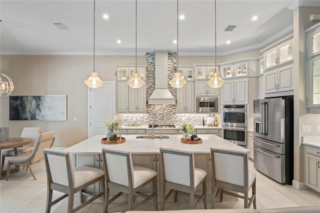 kitchen featuring stainless steel appliances, custom exhaust hood, a center island with sink, and pendant lighting