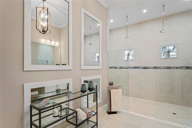 bathroom featuring a notable chandelier, tile patterned floors, crown molding, and tiled shower