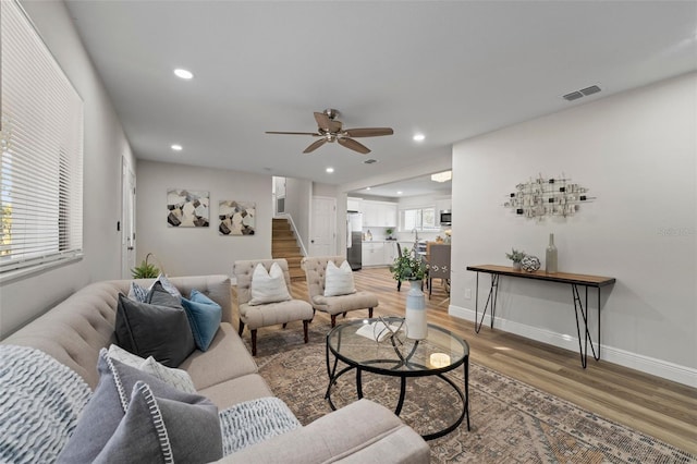 living room featuring ceiling fan, hardwood / wood-style floors, and sink