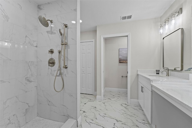 bathroom featuring a tile shower and vanity