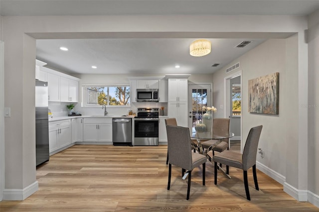 dining room featuring sink and light hardwood / wood-style floors