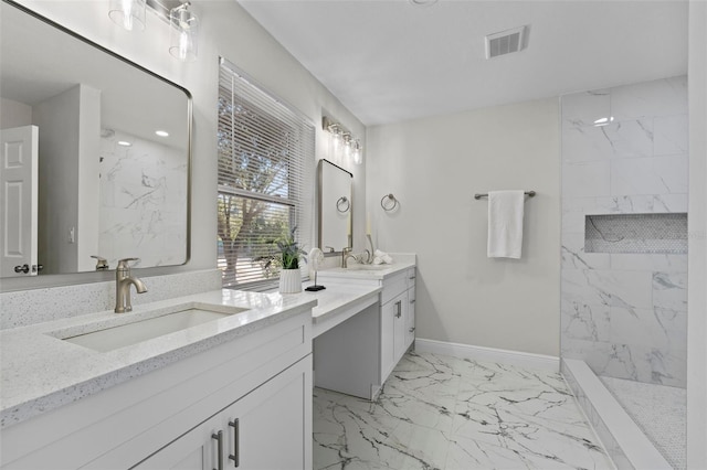 bathroom with vanity and a tile shower