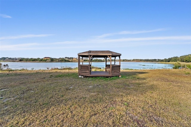 view of dock with a water view, a gazebo, and a lawn