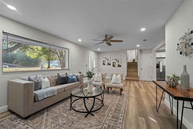 living room featuring ceiling fan and light hardwood / wood-style flooring