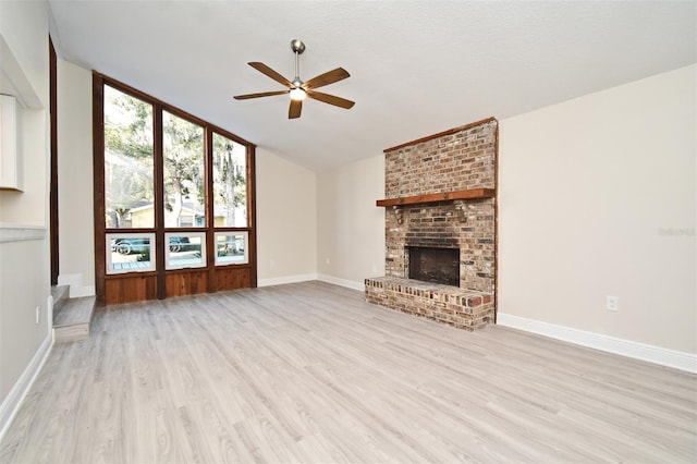 unfurnished living room with a fireplace, ceiling fan, vaulted ceiling, and light hardwood / wood-style floors