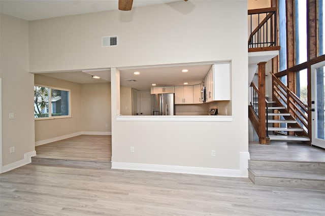 unfurnished living room with ceiling fan and light hardwood / wood-style flooring