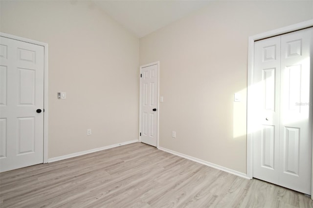 unfurnished bedroom featuring high vaulted ceiling and light hardwood / wood-style floors