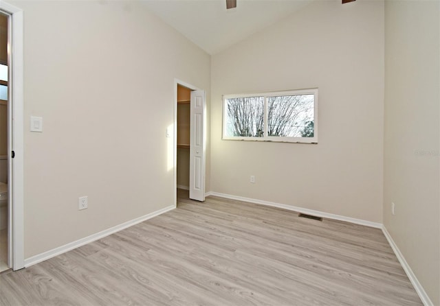 spare room with lofted ceiling and light hardwood / wood-style flooring