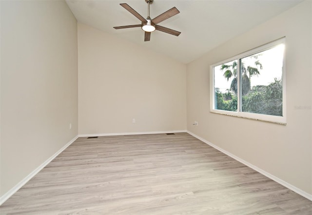 empty room featuring ceiling fan, light wood-type flooring, and vaulted ceiling