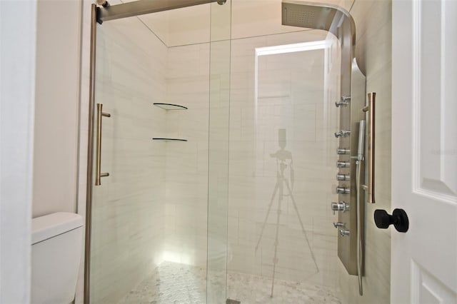 bathroom featuring an enclosed shower and toilet