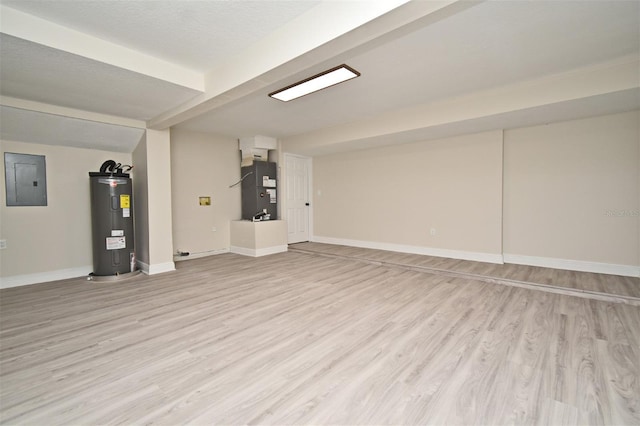 basement featuring electric water heater, electric panel, light hardwood / wood-style flooring, heating unit, and a textured ceiling