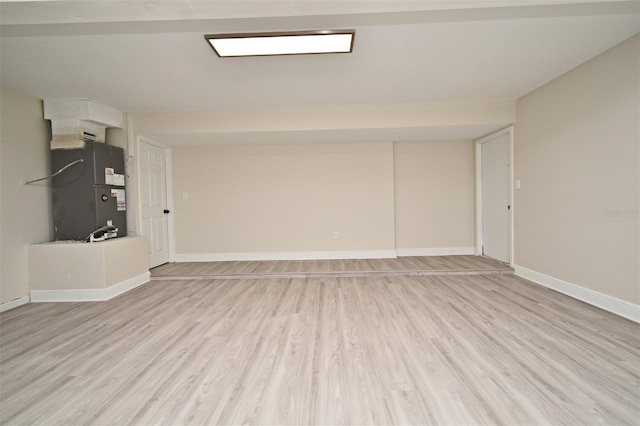 unfurnished living room featuring heating unit and light wood-type flooring