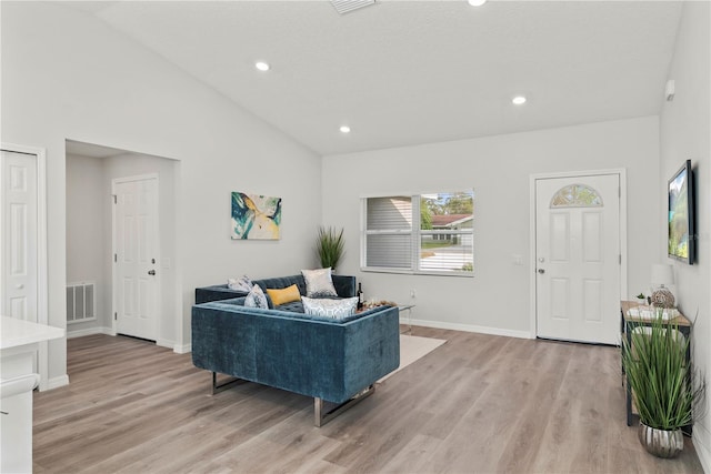 living room with high vaulted ceiling and light wood-type flooring