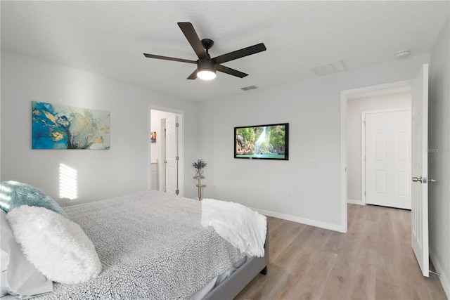 bedroom featuring ceiling fan, a textured ceiling, and light wood-type flooring