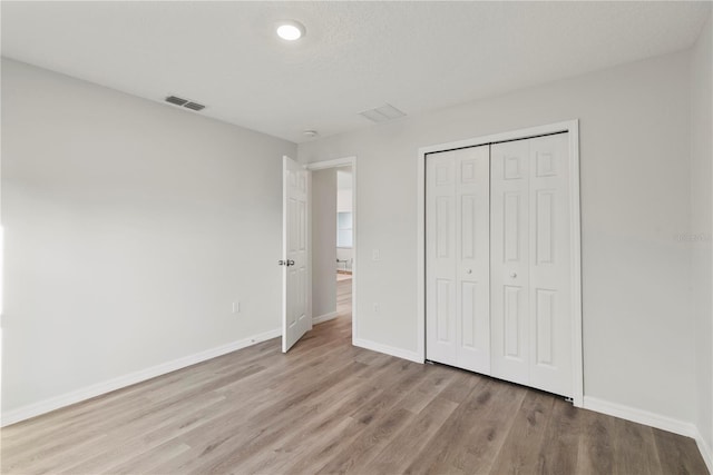 unfurnished bedroom with a closet and light hardwood / wood-style flooring