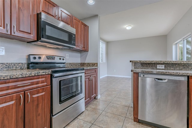 kitchen featuring light stone counters, light tile patterned floors, and stainless steel appliances