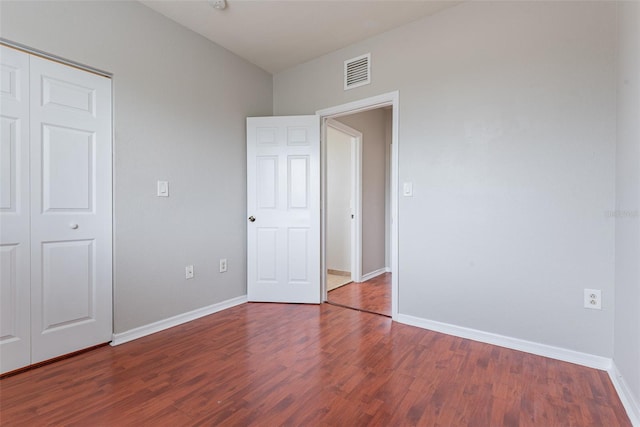 unfurnished bedroom with hardwood / wood-style flooring and a closet