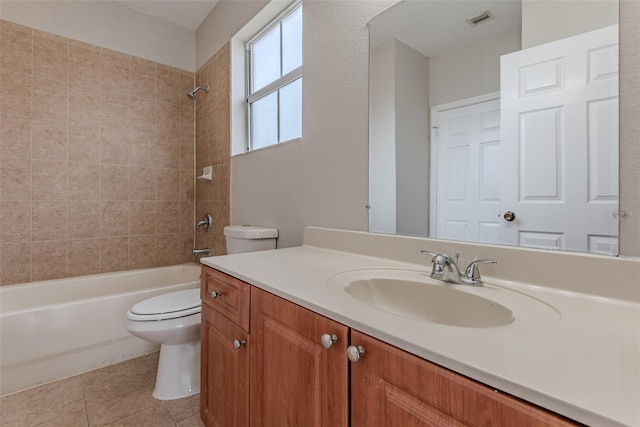 full bathroom with vanity, tiled shower / bath, tile patterned floors, and toilet