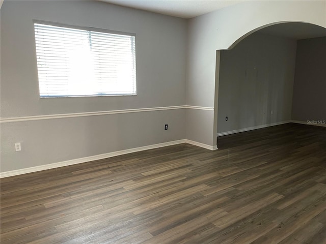 spare room with dark wood-type flooring