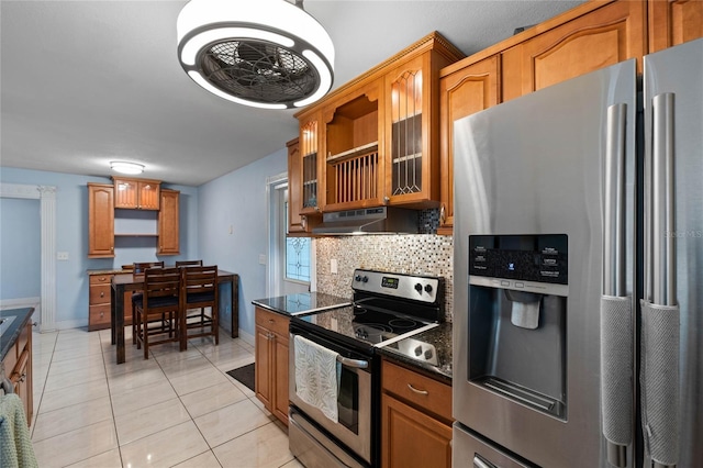 kitchen featuring light tile patterned flooring, tasteful backsplash, dark stone countertops, and stainless steel appliances