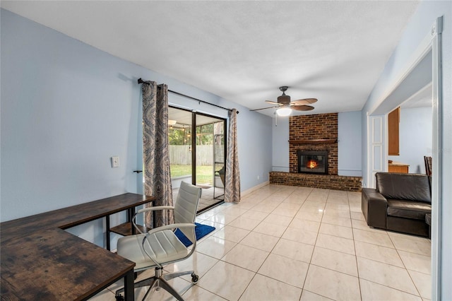 living room featuring ceiling fan, a fireplace, and light tile patterned flooring