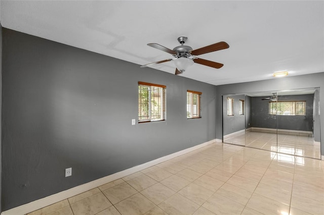 unfurnished room featuring ceiling fan, plenty of natural light, and light tile patterned flooring