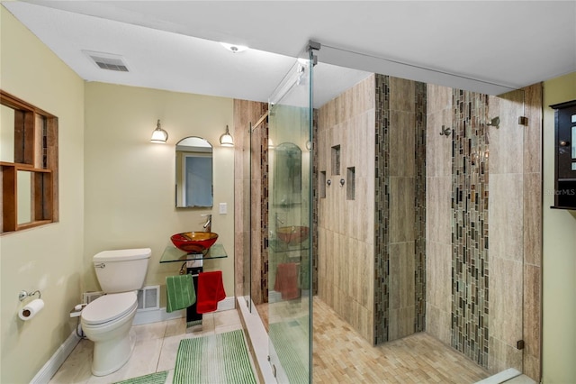 bathroom with sink, toilet, an enclosed shower, and tile patterned flooring